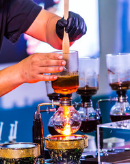 Fototapeta na wymiar Showcase Syphon Coffee maker by syphonist./ Syphon Coffee or Vacuum Coffee is full immersion tasteful, this process show mix coffee beans into boiling water. 