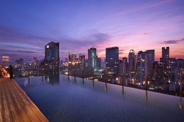Fototapeta na wymiar Cityscape sunset view of Bangkok modern office business building and high skyscraper in business district with infinity view swimming pool at Bangkok,Thailand.