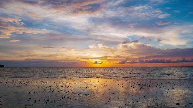 Time lapse tropical beach and sea at sunset. Colorful dramatic sky at dusk. Romantic passion concept. Tomia Island, Wakatobi national park, Indonesia.