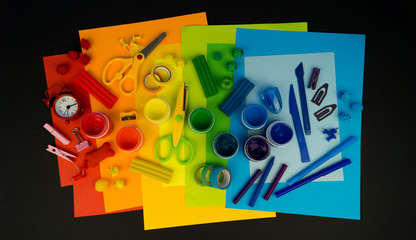 School accessories are laid out in the form of a rainbow. Black background.