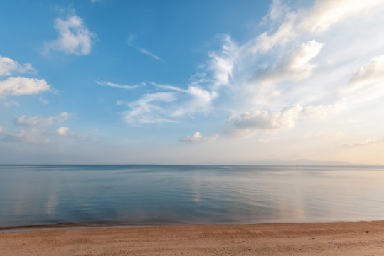 Bright beautiful seascape, sandy beach, clouds reflected in the water, natural minimalistic background and texture