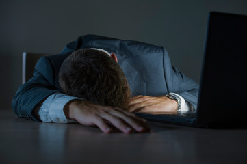 young attractive wasted and tired entrepreneur man sleeping taking nap late night at office laptop...