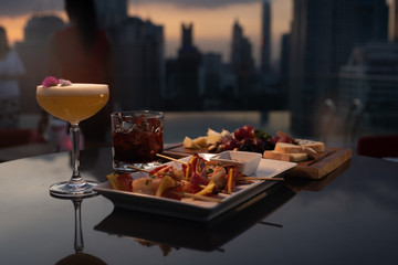 cocktails and food plate evening rooftop