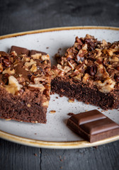 Chocolate brownie with walnuts on a plate.