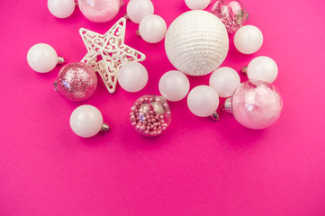 Fototapeta na wymiar Gentle pink and white baubles on a pink background. Christmas mood. Copy space