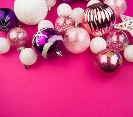 Gentle pink and purple baubles on a pink background. Christmas mood. Copy space