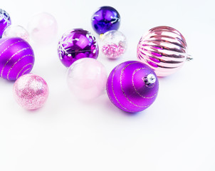 Gentle pink and purple baubles on a white background. Christmas mood. Copy space