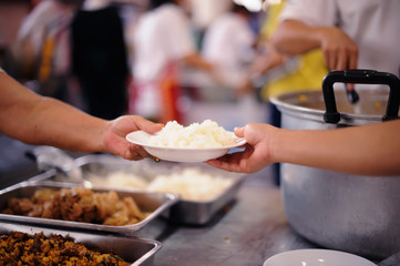 The hands of refugees have been aided by charity food to alleviate hunger : the concept of humanitarianism.