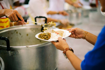 The hands of refugees have been aided by charity food to alleviate hunger : the concept of...
