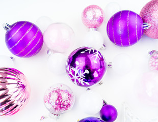 Gentle pink and purple baubles on a white background. Christmas mood.