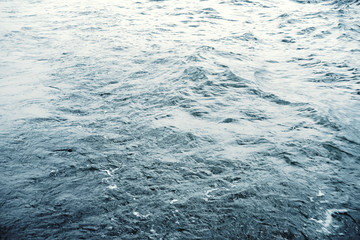 Water surface with ripples and sunlight reflections