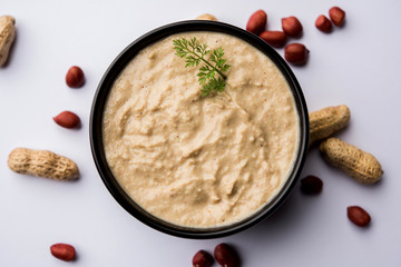 Healthy Peanut chutney made using Groundnut / Shengdana or mungfali. served in a small bowl with raw whole. Selective focus