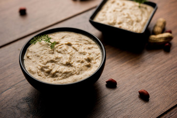 Healthy Peanut chutney made using Groundnut / Shengdana or mungfali. served in a small bowl with raw whole. Selective focus