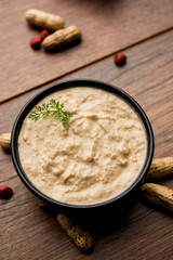 Healthy Peanut chutney made using Groundnut / Shengdana or mungfali. served in a small bowl with raw whole. Selective focus