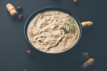 Healthy Peanut chutney made using Groundnut / Shengdana or mungfali. served in a small bowl with raw whole. Selective focus