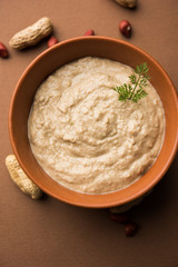 Healthy Peanut chutney made using Groundnut / Shengdana or mungfali. served in a small bowl with raw whole. Selective focus