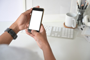Fototapeta na wymiar Mockup smartphone on man hands empty display with office desk background.