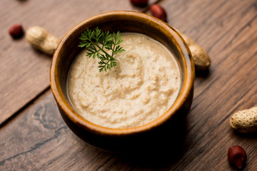 Healthy Peanut chutney made using Groundnut / Shengdana or mungfali. served in a small bowl with raw whole. Selective focus