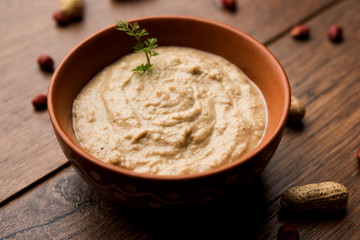 Healthy Peanut chutney made using Groundnut / Shengdana or mungfali. served in a small bowl with raw whole. Selective focus