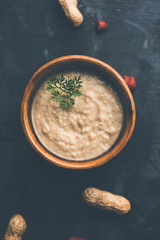 Healthy Peanut chutney made using Groundnut / Shengdana or mungfali. served in a small bowl with raw whole. Selective focus