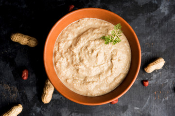 Healthy Peanut chutney made using Groundnut / Shengdana or mungfali. served in a small bowl with raw whole. Selective focus