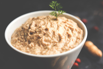 Healthy Peanut chutney made using Groundnut / Shengdana or mungfali. served in a small bowl with raw whole. Selective focus