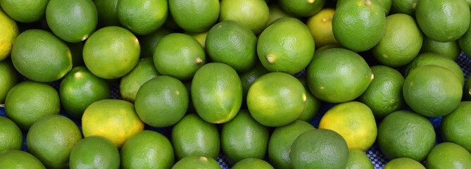 green fresh lemon lime texture background / pile of lime lemon for sale in the market