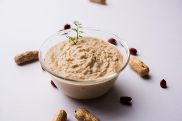 Healthy Peanut chutney made using Groundnut / Shengdana or mungfali. served in a small bowl with raw whole. Selective focus