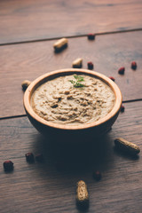 Healthy Peanut chutney made using Groundnut / Shengdana or mungfali. served in a small bowl with raw whole. Selective focus