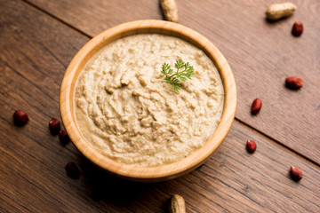 Healthy Peanut chutney made using Groundnut / Shengdana or mungfali. served in a small bowl with raw whole. Selective focus