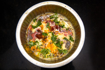 Beaten up egg yolk with raw spices turmeric powder, red chili powder, black pepper powder, coriander leaves