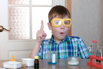 Experiments on chemistry at home. Insight or idea of a young scientist. Boy in plaid shirt and...