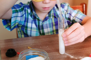 Experiments on chemistry at home. Boy Pour the water to test tube using pipette.