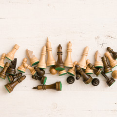 Closeup on chess figures on white wooden table background.