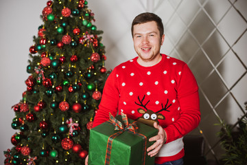 Young plump guy at winter holiday, Christmas time, plus size man at cozy home