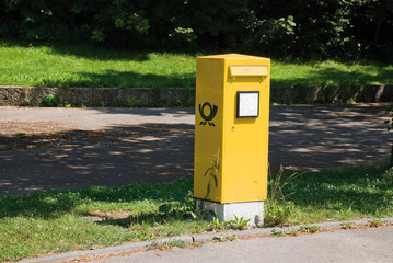 Fototapeta na wymiar Isoliert stehender Briefkasten der Deutschen Post