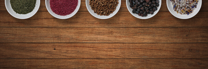 Spices in bowls on wooden background