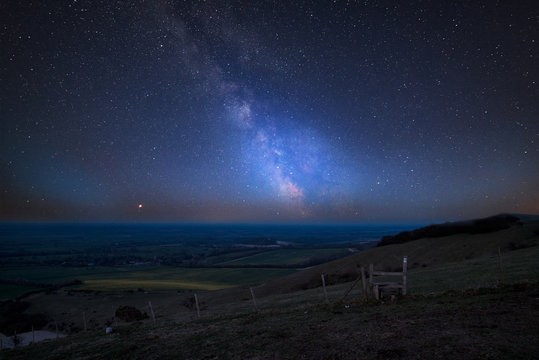 Vibrant Milky Way composite image over landscape of countryside in Summer