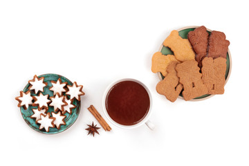 A photo of Zimtsterne and Spekulatius, traditional Christmas cookies, shot from the top on a white background with hot chocolate, spices, and copy space
