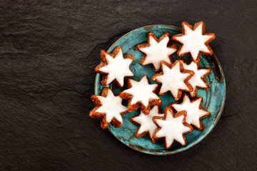 Christmas Zimtsterne, traditional German almond, chocolate and cinnamon star cookies, shot from the top on a dark background with copy space