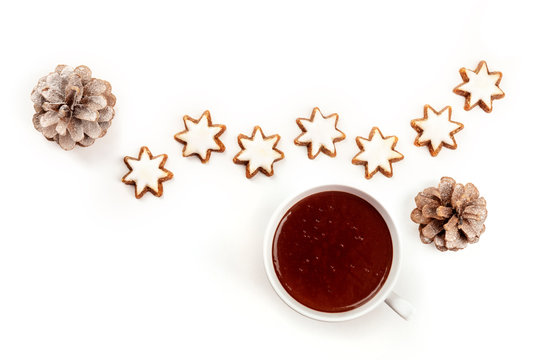 An Overhead Photo Of Zimtsterne, Traditional Christmas Cinnamon Star Cookies, Shot From The Top On A White Background With Hot Chocolate, Pine Cones, And Copy Space