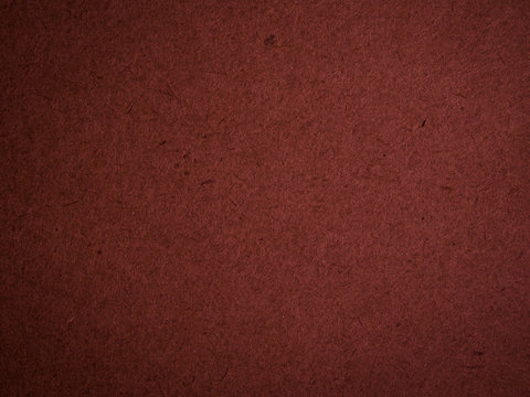 Texture of dark red cardboard closeup, abstract paper background