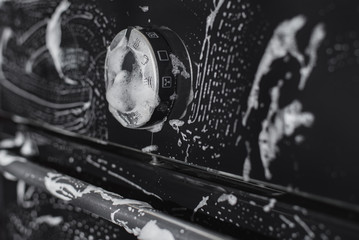 Antibacterial processing of kitchen appliances with detergents, on the black glass surface of the...