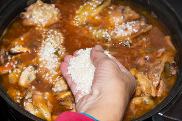 cooking tasty rice with seafood- paella a la marinera