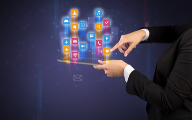 Female elegant hand holding tablet with colourful application icons