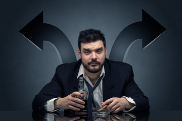 Drunk disappointed man sitting at table with arrows around
