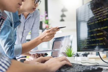 Asian team Outsource Developer Looking Screen Programming Code Working with Laptop Computer...