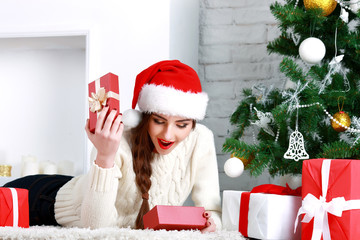 Happy young woman lying on the floor with gift box