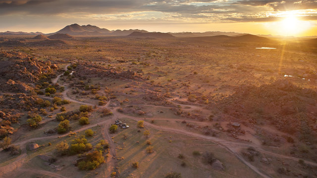 Aerial photo of sunrise over rocky desert, long shadows and beautiful colors. Morning in vaste wilderness without people, close to Spreetshoogte Pass, Nauchas, Namibia.