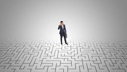 Elegant businessman looking for a solution in a middle of a maze

